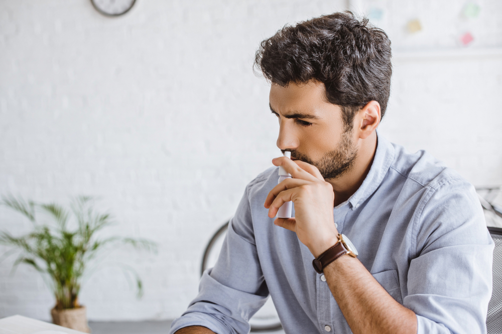 man using nasal spray.